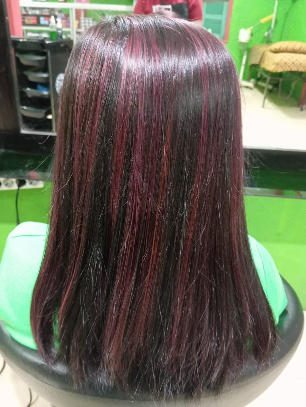 Highlight warna merah keunguan pada rambut hitam panjang